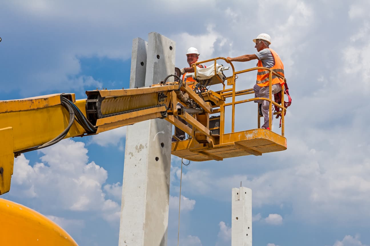 DEUX TRAVAILLEURS EN GILET ORANGE DANS NACELLE 2